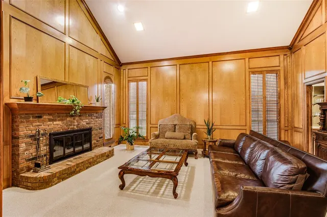 a living room with furniture a fireplace and large windows