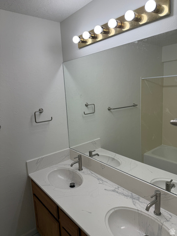 747 Hanover Drive Orem, UT 84058 - Photo 17 of 30 Full bath featuring double vanity, a textured ceiling, and washtub / shower combination