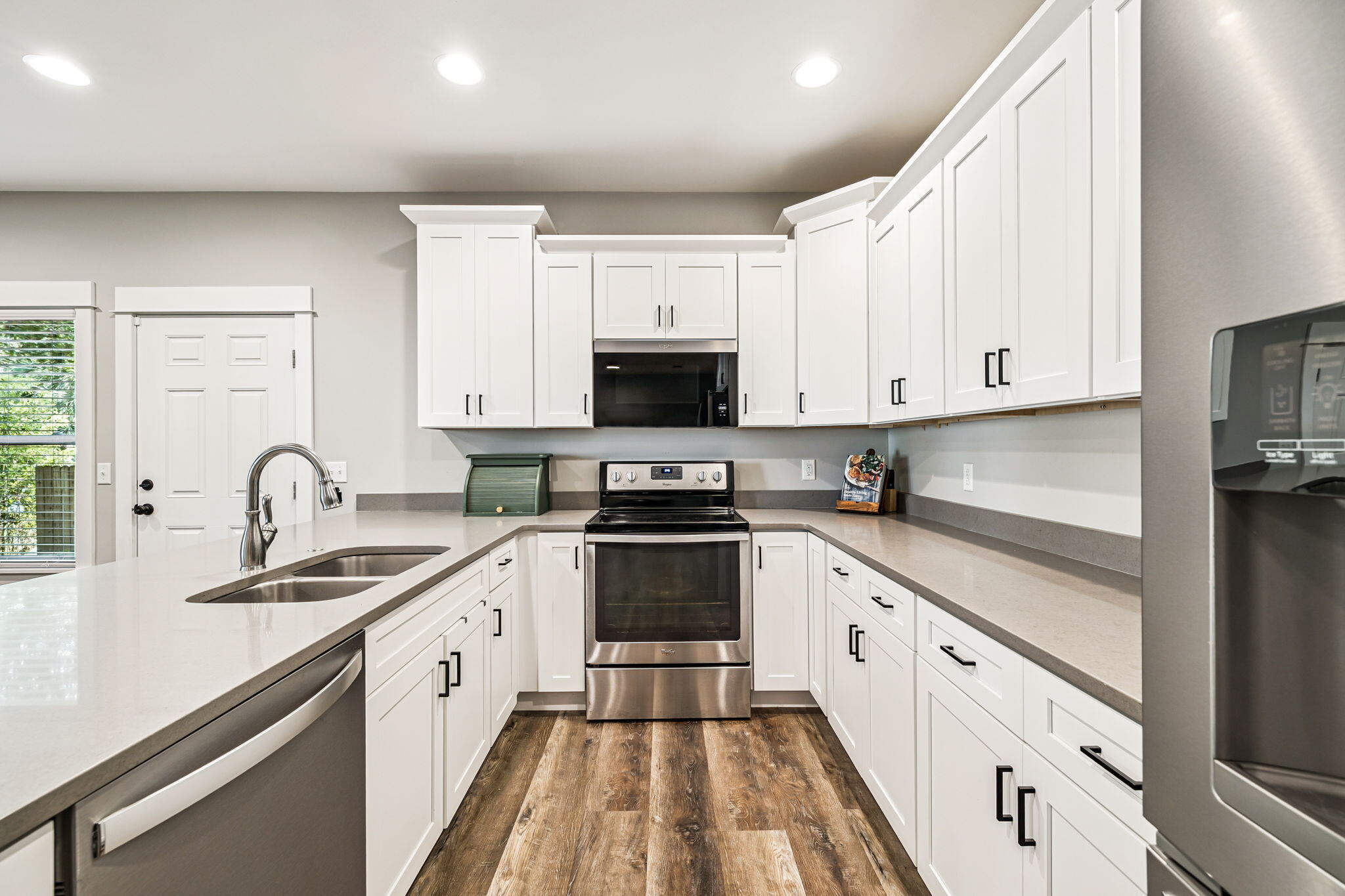 82 Live Oak Street Freeport, FL 32439 - Photo 6 of 22 a large white kitchen with stainless steel appliances granite countertop a stove a sink and a microwave