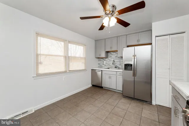 a kitchen with white cabinets and white appliances