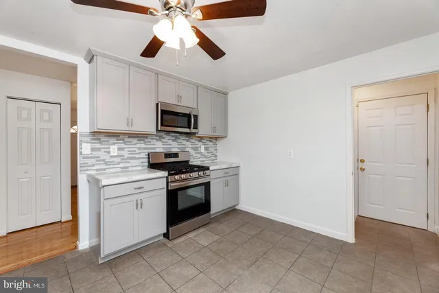 a kitchen with granite countertop a stove top oven microwave and cabinets