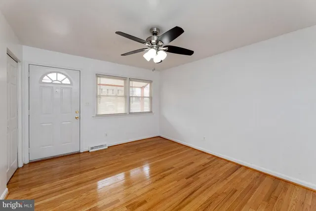 a view of empty room with wooden floor