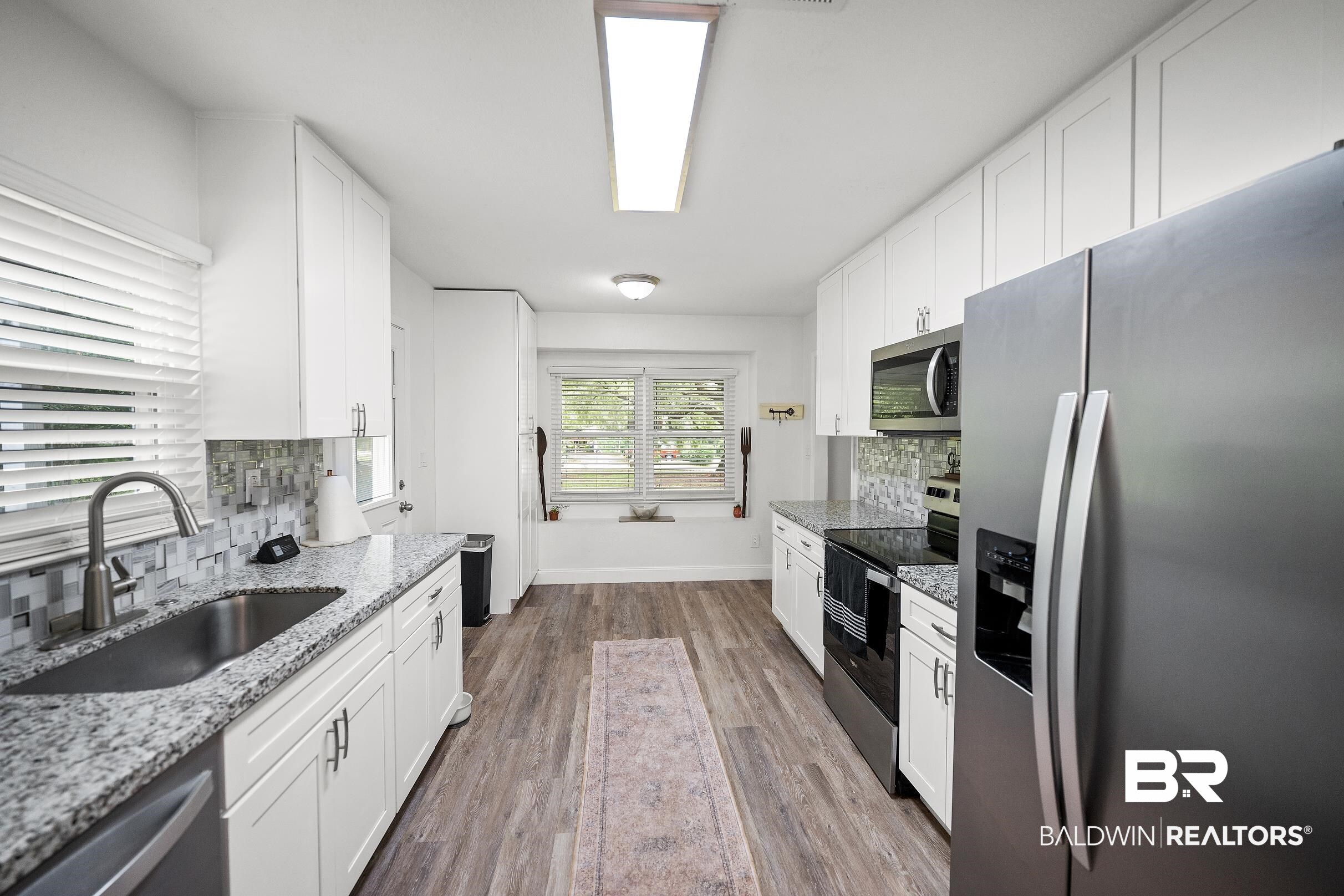 33129 Antietam Road Lillian, AL 36549 - Photo 6 of 31 Galley kitchen featuring white cabinetry, granite countertops, and stainless steel appliances