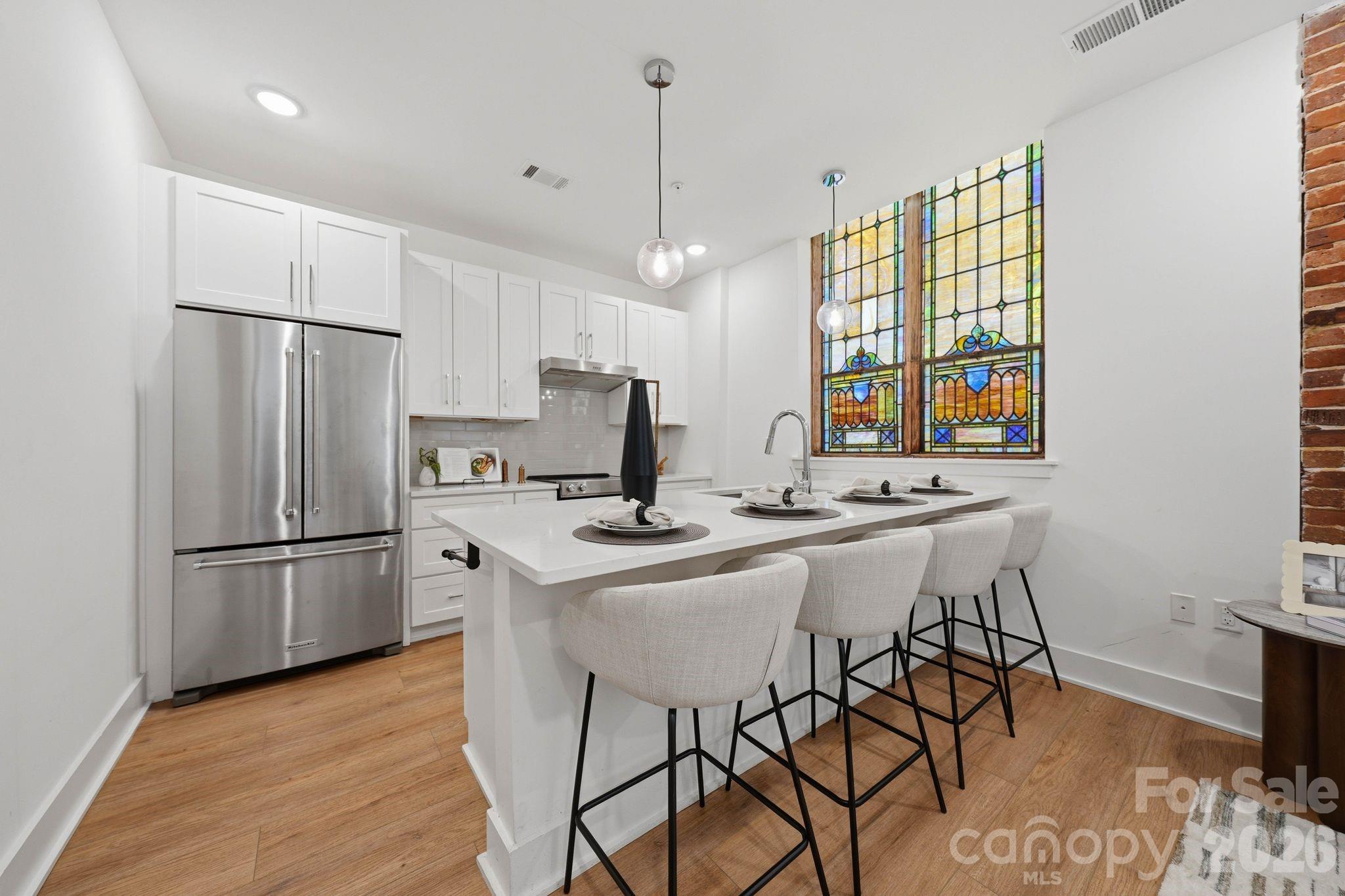 201 Grandin Road, Unit 9 Charlotte, NC 28208 - Photo 11 of 43 a kitchen with stainless steel appliances a refrigerator a sink a stove a dining table and chairs