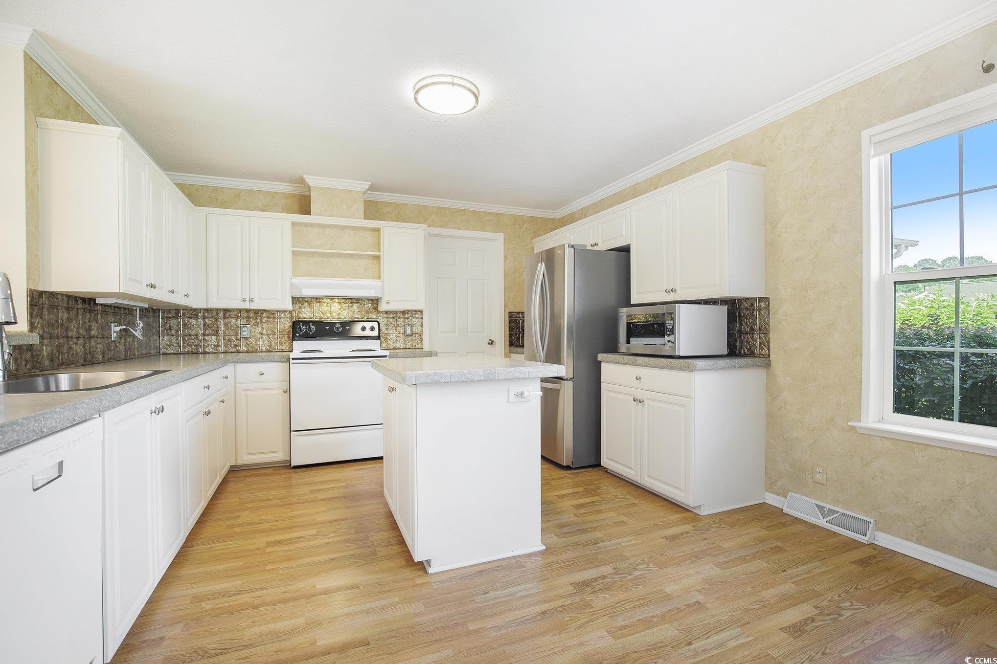 237 Wellspring Drive Conway, SC 29526 - Photo 32 of 33 Kitchen featuring pendant lighting, open floor plan, dark wood-type flooring, white appliances, and ornamental molding