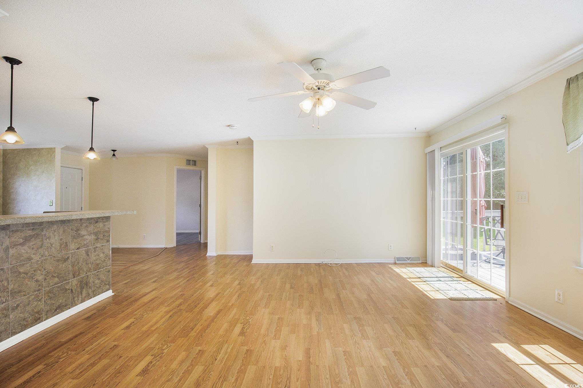 237 Wellspring Drive Conway, SC 29526 - Photo 33 of 33 Kitchen featuring open floor plan, a kitchen island, ornamental molding, hanging light fixtures, and white cabinets