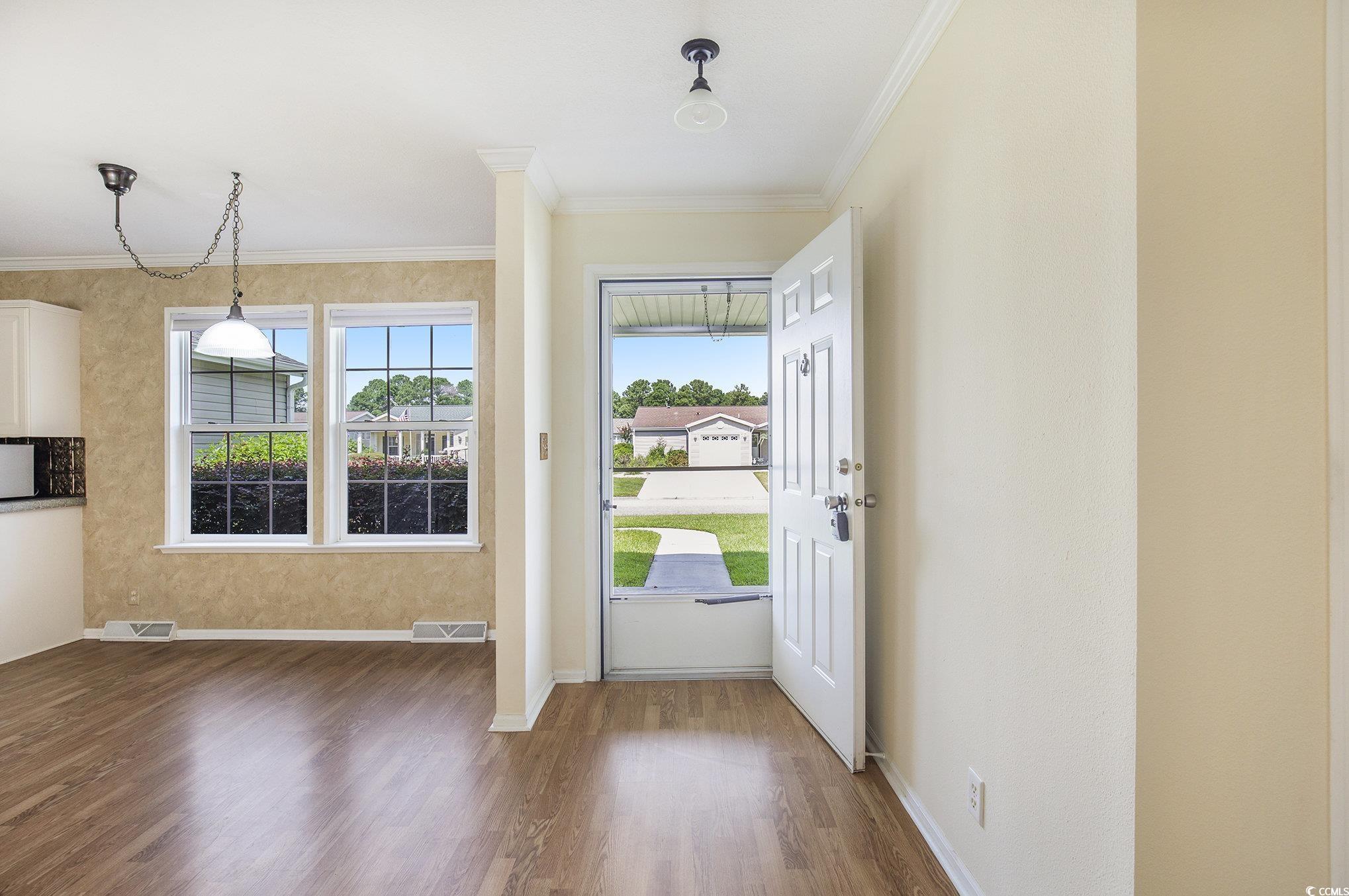 237 Wellspring Drive Conway, SC 29526 - Photo 9 of 33 Empty room featuring plenty of natural light, light wood-style flooring, ornamental molding, and a ceiling fan