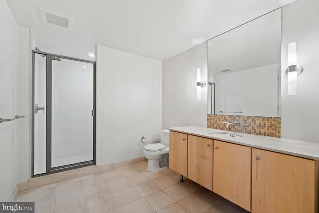 a bathroom with a granite countertop sink a toilet and a mirror