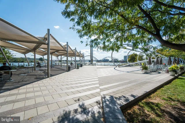 a view of swimming pool with seating space and trees in the background