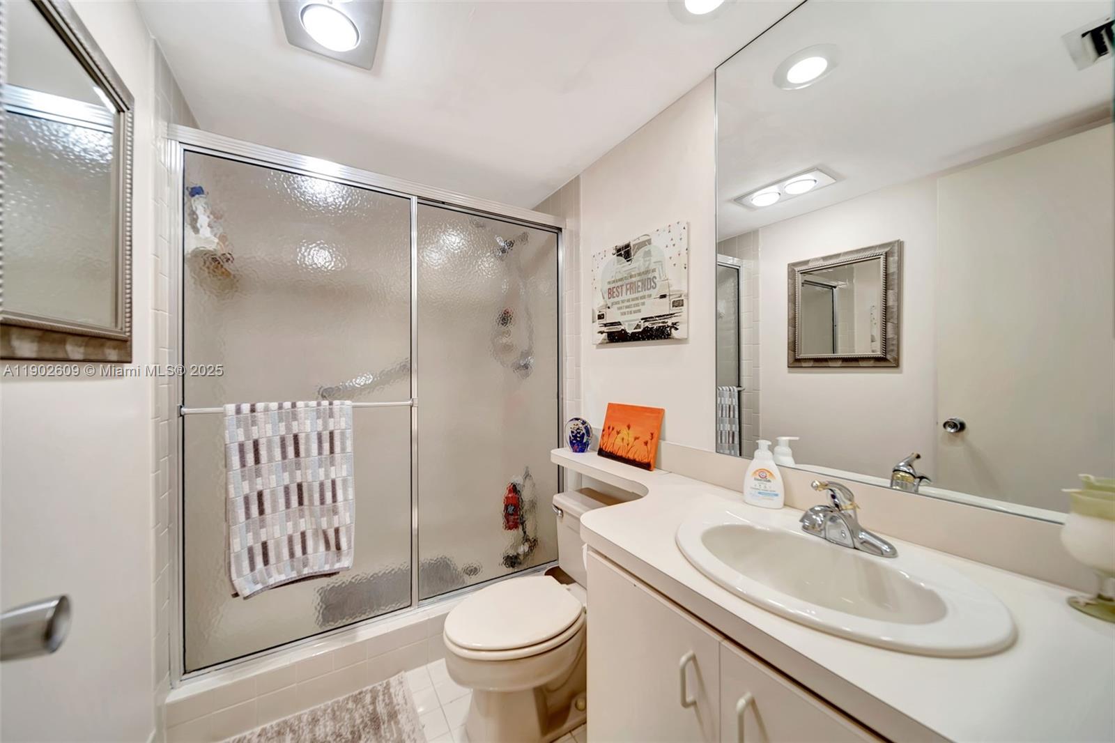 3980 Oaks Clubhouse Drive, Unit 409 Pompano Beach, FL 33069 - Photo 22 of 70 a bathroom with a sink toilet and shower