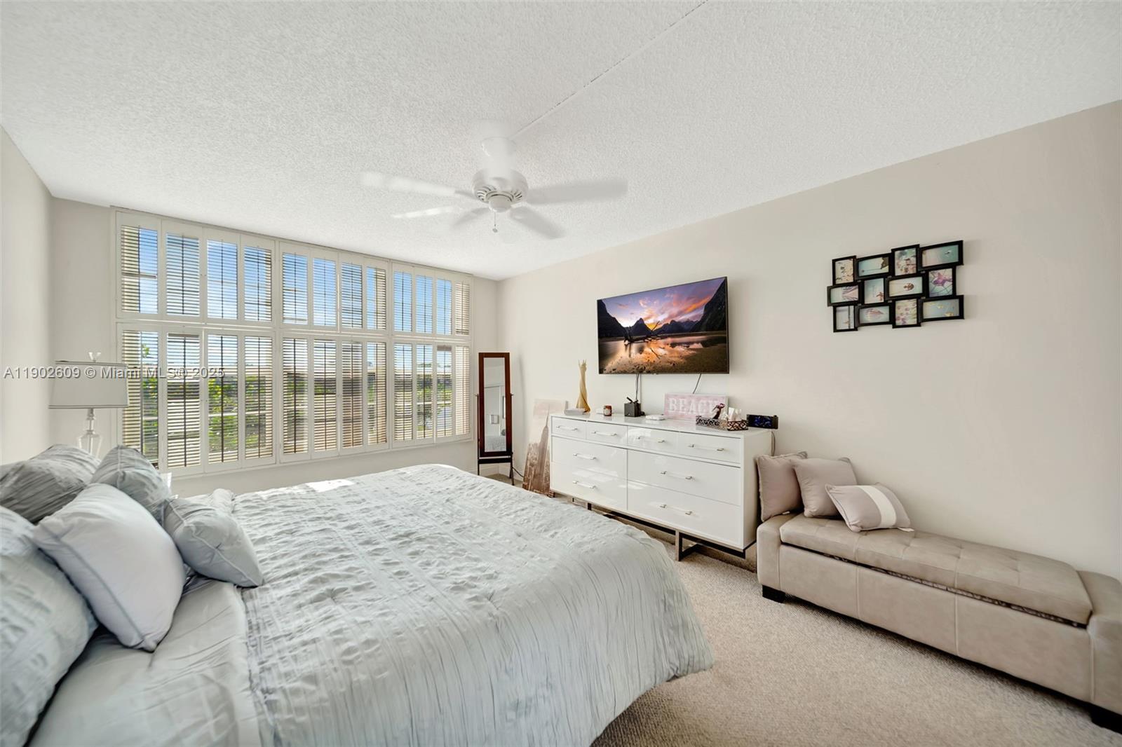 3980 Oaks Clubhouse Drive, Unit 409 Pompano Beach, FL 33069 - Photo 27 of 70 a spacious bedroom with a bed and a couch