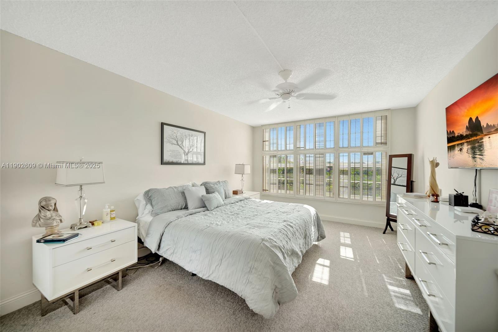 3980 Oaks Clubhouse Drive, Unit 409 Pompano Beach, FL 33069 - Photo 28 of 70 a spacious bedroom with a bed and a flat screen tv