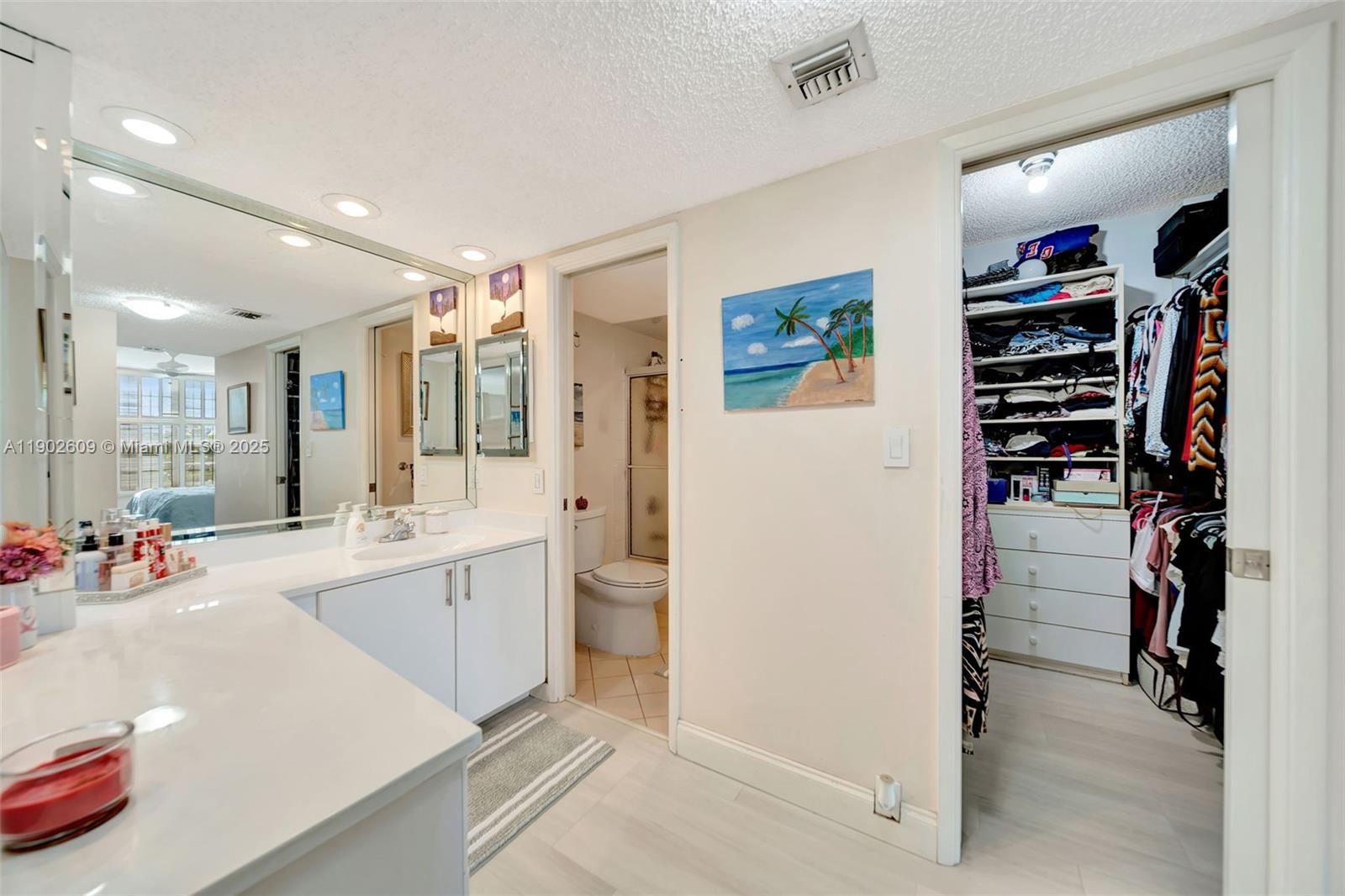 3980 Oaks Clubhouse Drive, Unit 409 Pompano Beach, FL 33069 - Photo 33 of 70 Directly off the vanity, you’ll find easy access to the walk-in closet, private water closet, and bedroom — all connected for comfort and flow. Everything you need is right where you need it.