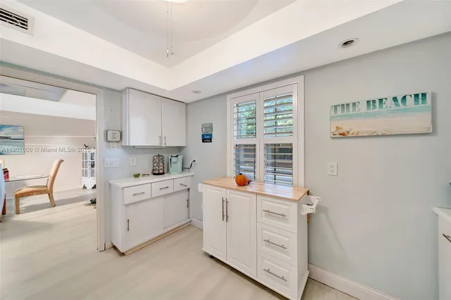a kitchen with stainless steel appliances a white cabinets and wooden floors