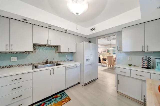 a kitchen with white cabinets and white appliances