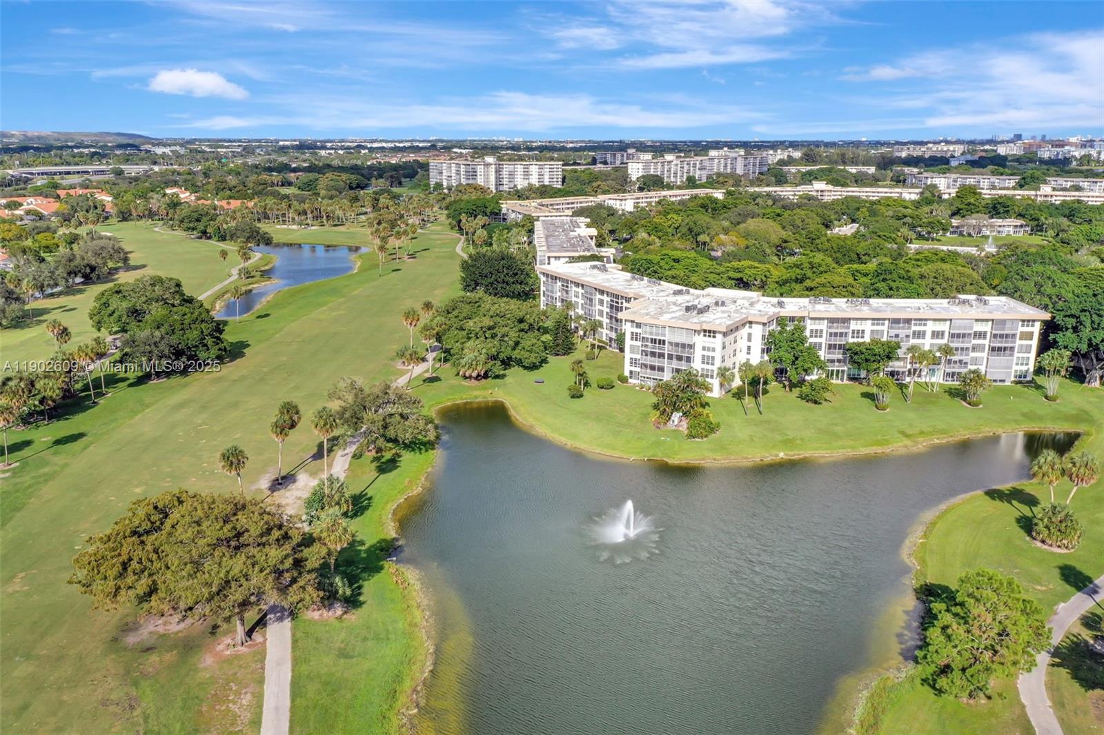 3980 Oaks Clubhouse Drive, Unit 409 Pompano Beach, FL 33069 - Photo 60 of 70 a view of a lake with a mountain in the background