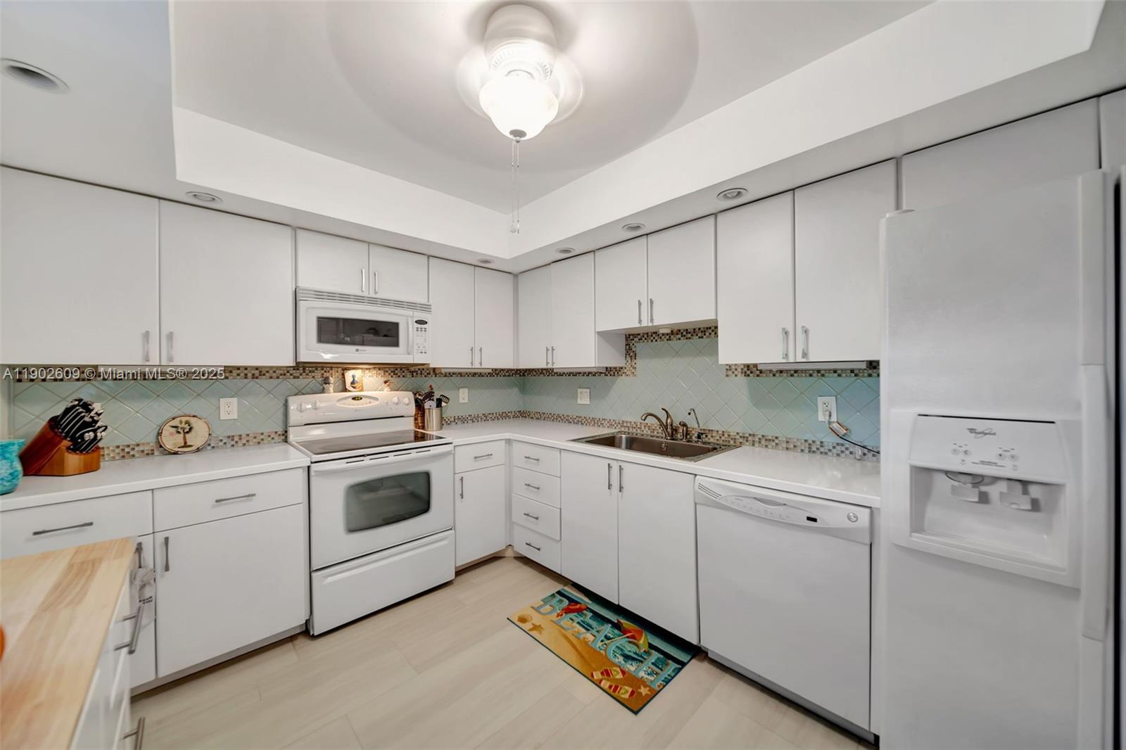 3980 Oaks Clubhouse Drive, Unit 409 Pompano Beach, FL 33069 - Photo 6 of 70 a kitchen with cabinets appliances a sink and a counter top