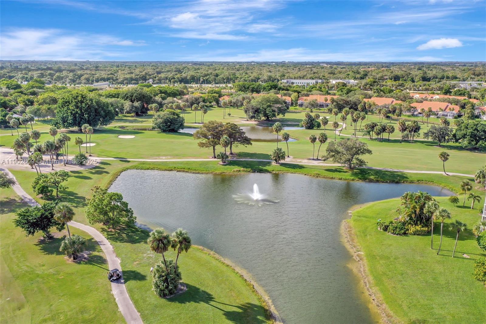 3980 Oaks Clubhouse Drive, Unit 409 Pompano Beach, FL 33069 - Photo 64 of 70 Aerial view of the lush golf course and lake — wide fairways, tranquil water features, and palm-dotted greens wrap the community in resort-style scenery.