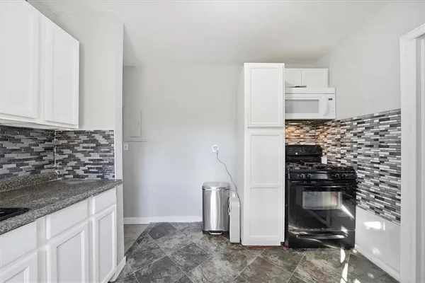 a kitchen with a refrigerator and a stove top oven