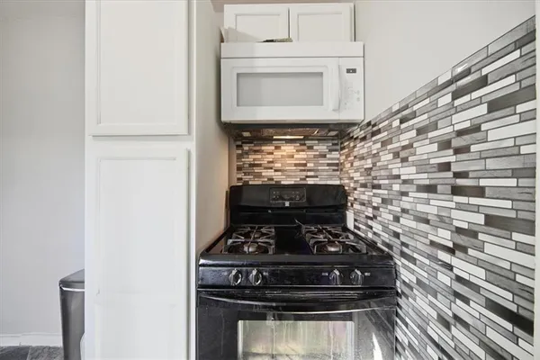 a stove top oven sitting inside of a kitchen