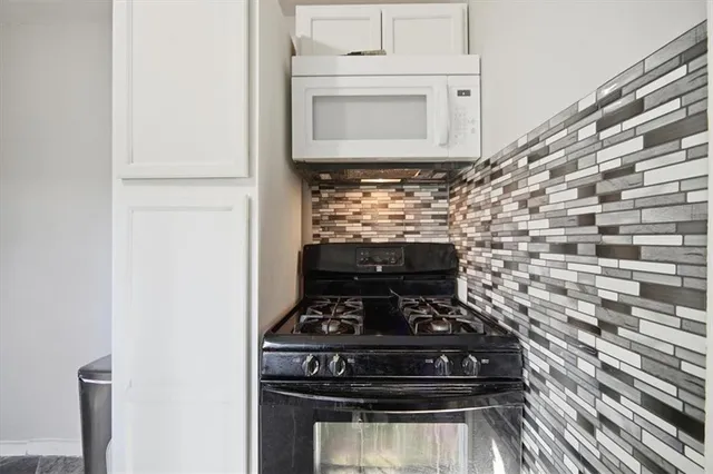 a stove top oven sitting inside of a kitchen