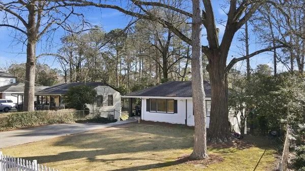 a white house that has a tree in front of it