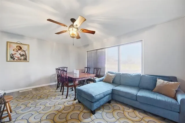 a living room with furniture a ceiling fan and a rug