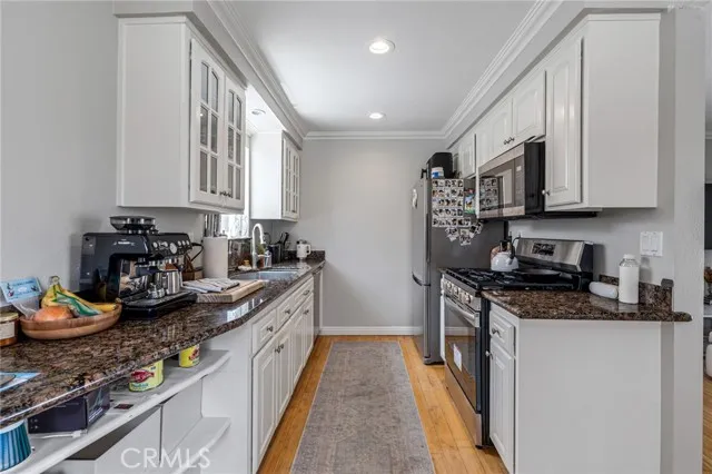 209 13th Street, Unit D Huntington Beach, CA 92648 - Photo 11 of 34 a kitchen with stainless steel appliances granite countertop a stove a sink and a refrigerator