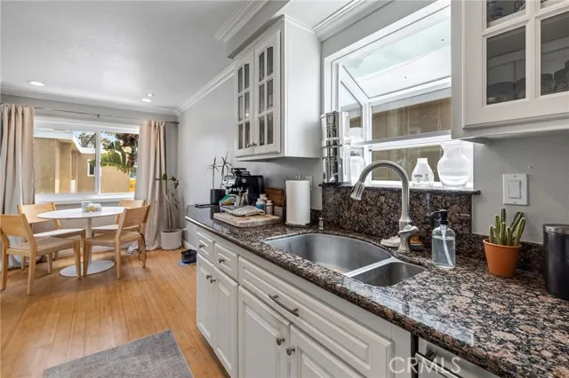 209 13th Street, Unit D Huntington Beach, CA 92648 - Photo 12 of 34 a kitchen with a granite countertop sink stove and cabinets