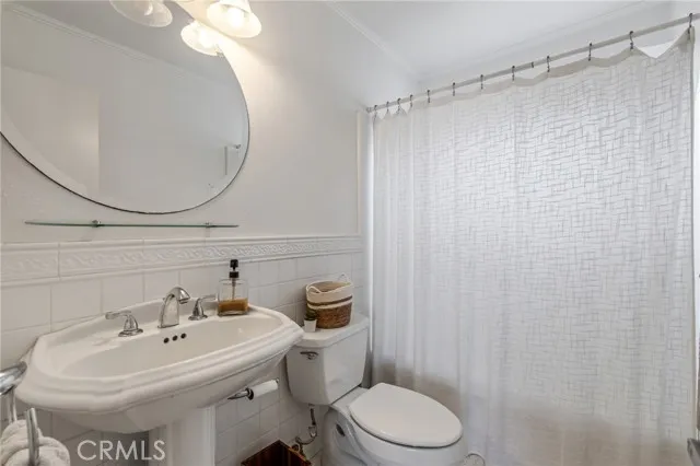 209 13th Street, Unit D Huntington Beach, CA 92648 - Photo 21 of 34 a bathroom with a sink a toilet and a mirror