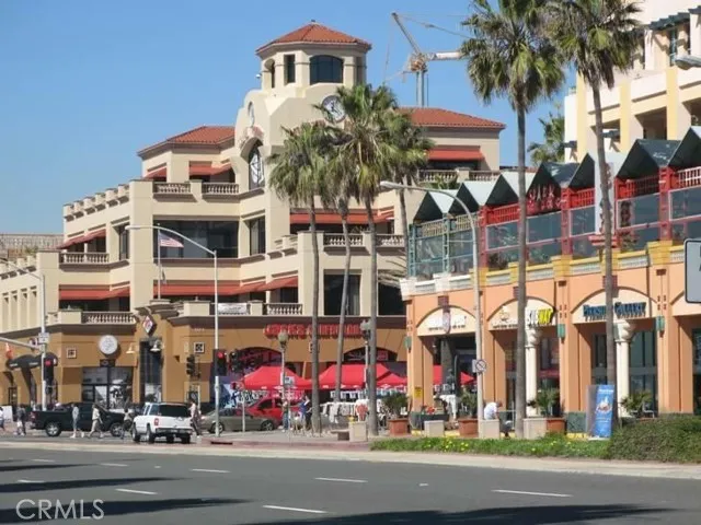 209 13th Street, Unit D Huntington Beach, CA 92648 - Photo 34 of 34 a front view of multi story residential apartment building with yard and parking