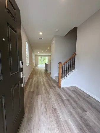 a view of entryway and hall with wooden floor
