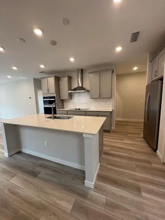 a large white kitchen with wooden floor and a sink