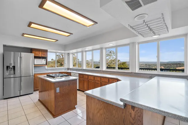 a kitchen with stainless steel appliances granite countertop a sink a stove and a refrigerator