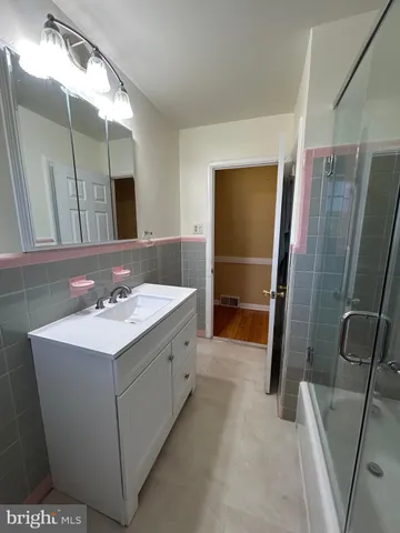 a bathroom with a sink a toilet a mirror and shower