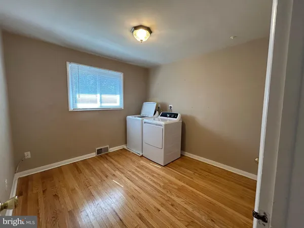 a utility room with wooden floor washer and dryer
