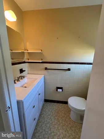a bathroom with a sink a toilet a mirror and vanity