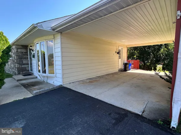 a view of a patio with table and chairs and a barbeque
