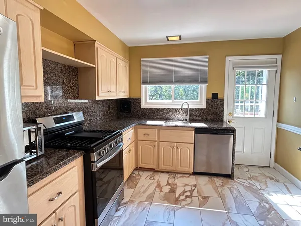 a kitchen with granite countertop a stove sink and cabinets