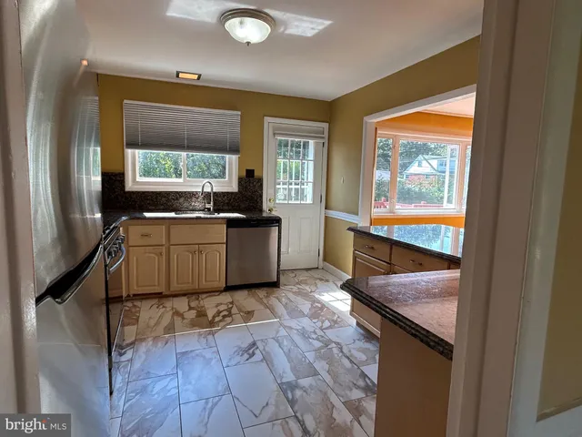 a kitchen with stainless steel appliances granite countertop a sink and a wooden cabinets