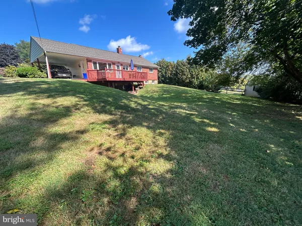 a view of a backyard with wooden fence and a bench