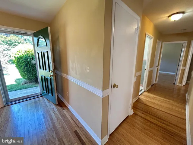 a view of a hallway with wooden floor and stairs