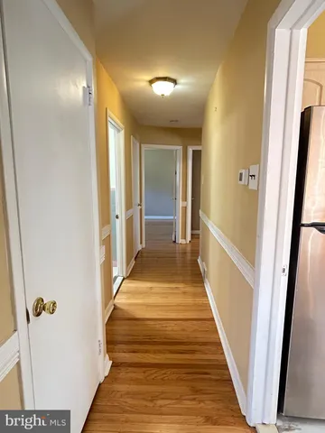 a view of a hallway with wooden floor and staircase