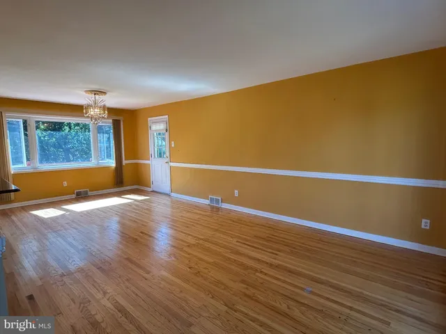 a view of a room with wooden floor and window