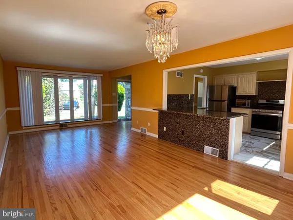 an empty room with wooden floor and large windows