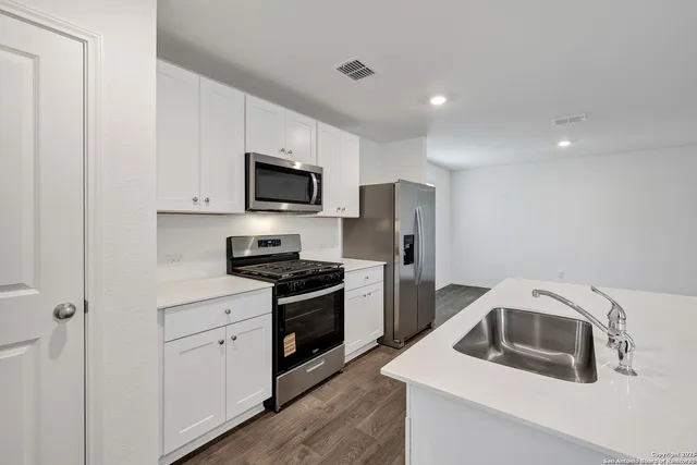 a kitchen with a sink stove and refrigerator