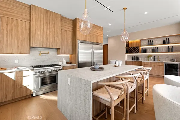 a large kitchen with kitchen island a stove a sink a refrigerator and a dining table