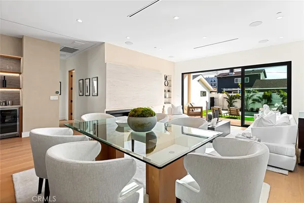 a living room with couches a coffee table and kitchen view with wooden floor