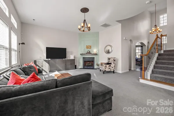 a living room with furniture kitchen area and a fireplace