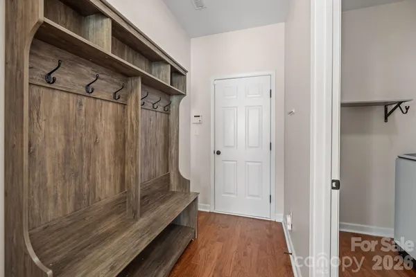 a view of a closet area with wooden floor